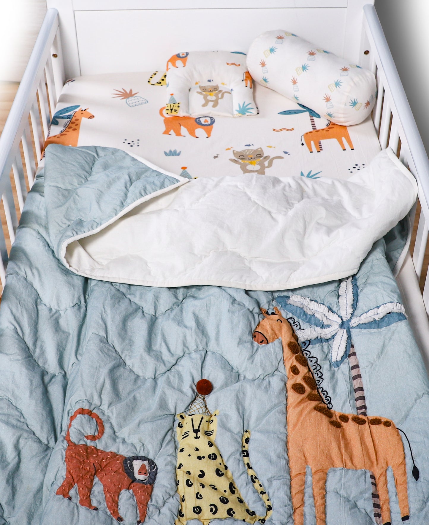 Children's crib with animal-themed bedding and pillows