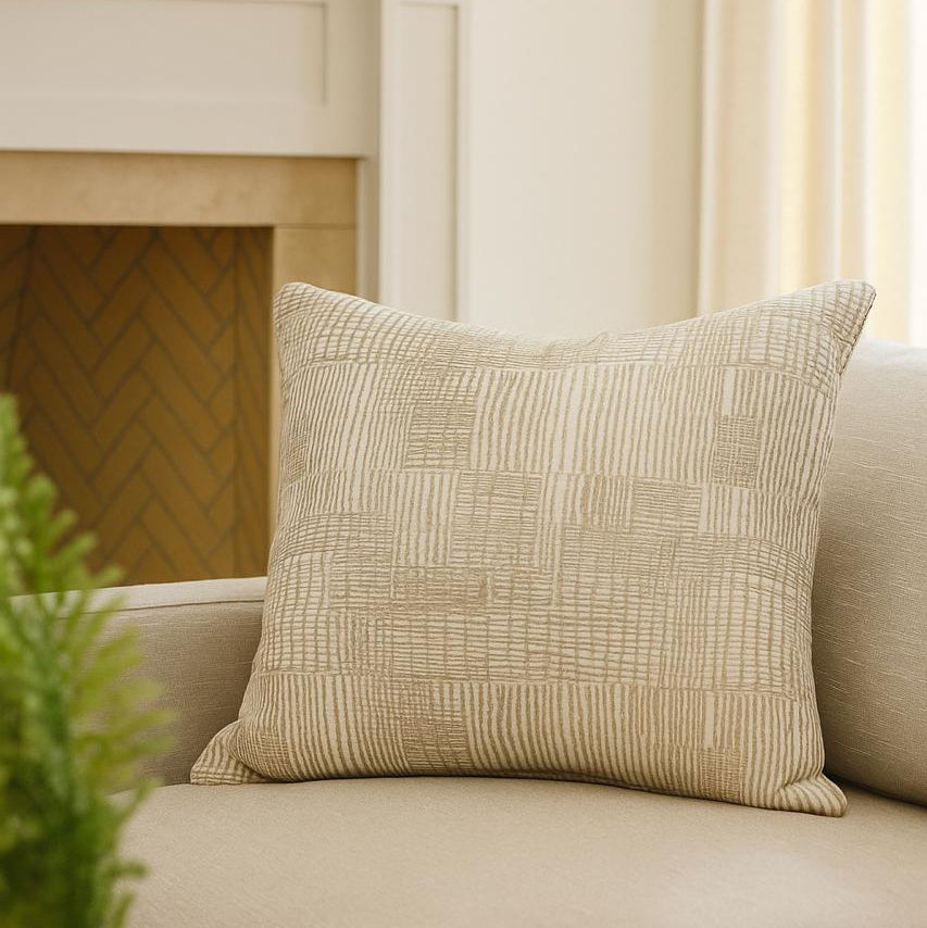 Textured beige pillow on a beige sofa with a blurred background