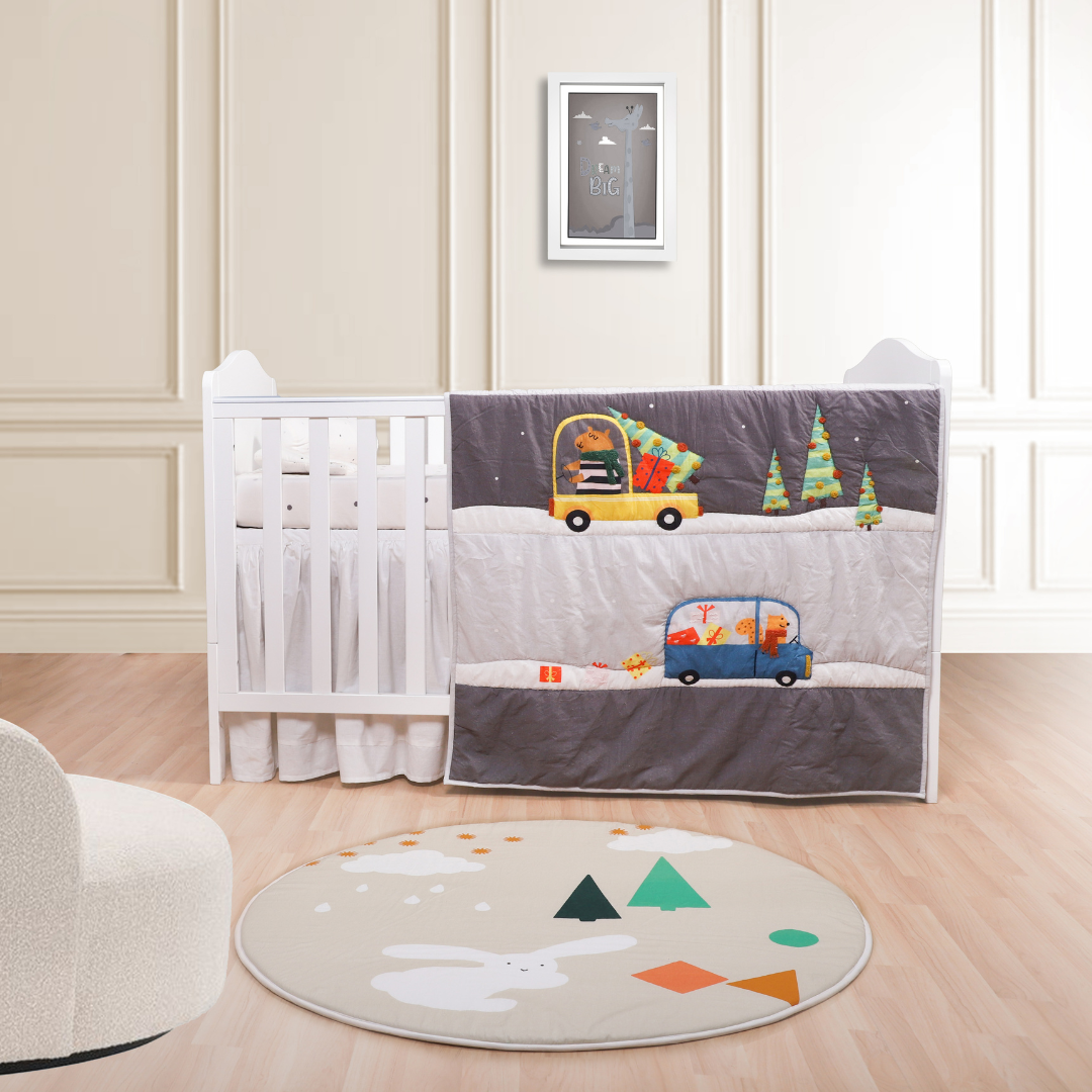 A baby quilt with a car and pig pattern displayed on a crib in a nursery room.