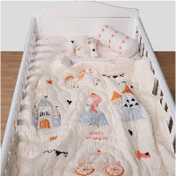 A baby quilt with a fairy-tale theme, featuring designs such as a castle, princess crown, horse, and carriage, in soft pastel colors displayed on a crib.