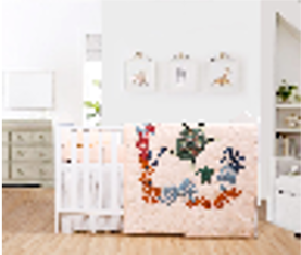 A baby quilt with a turtle and sea plant design displayed on a crib in a nursery room.