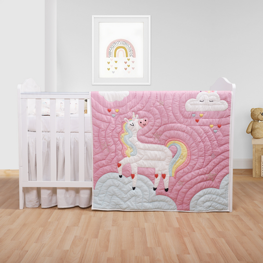 A colorful unicorn princess quilt with a fitted sheet, bolster, and baby pillow displayed in a nursery setting.