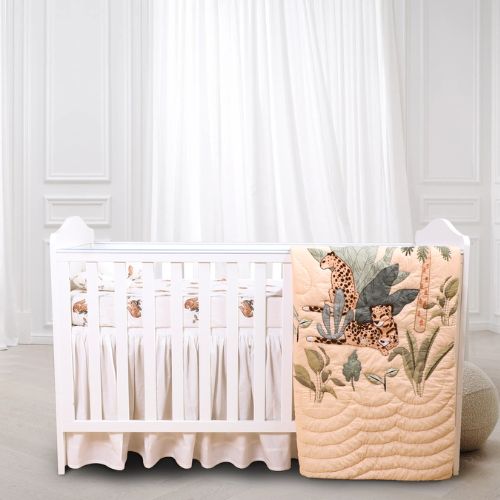 A baby quilt set with a safari theme, featuring printed leopards, displayed on a crib with white bedding.