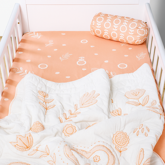 Crib with floral-patterned bedding and pillow