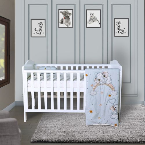 A baby quilt with a design featuring a baby elephant and a rainbow, displayed in a nursery room.