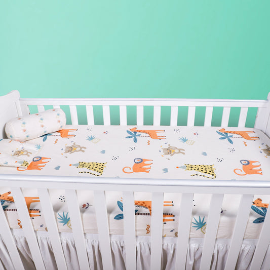 White crib with colorful baby sheet against a teal background