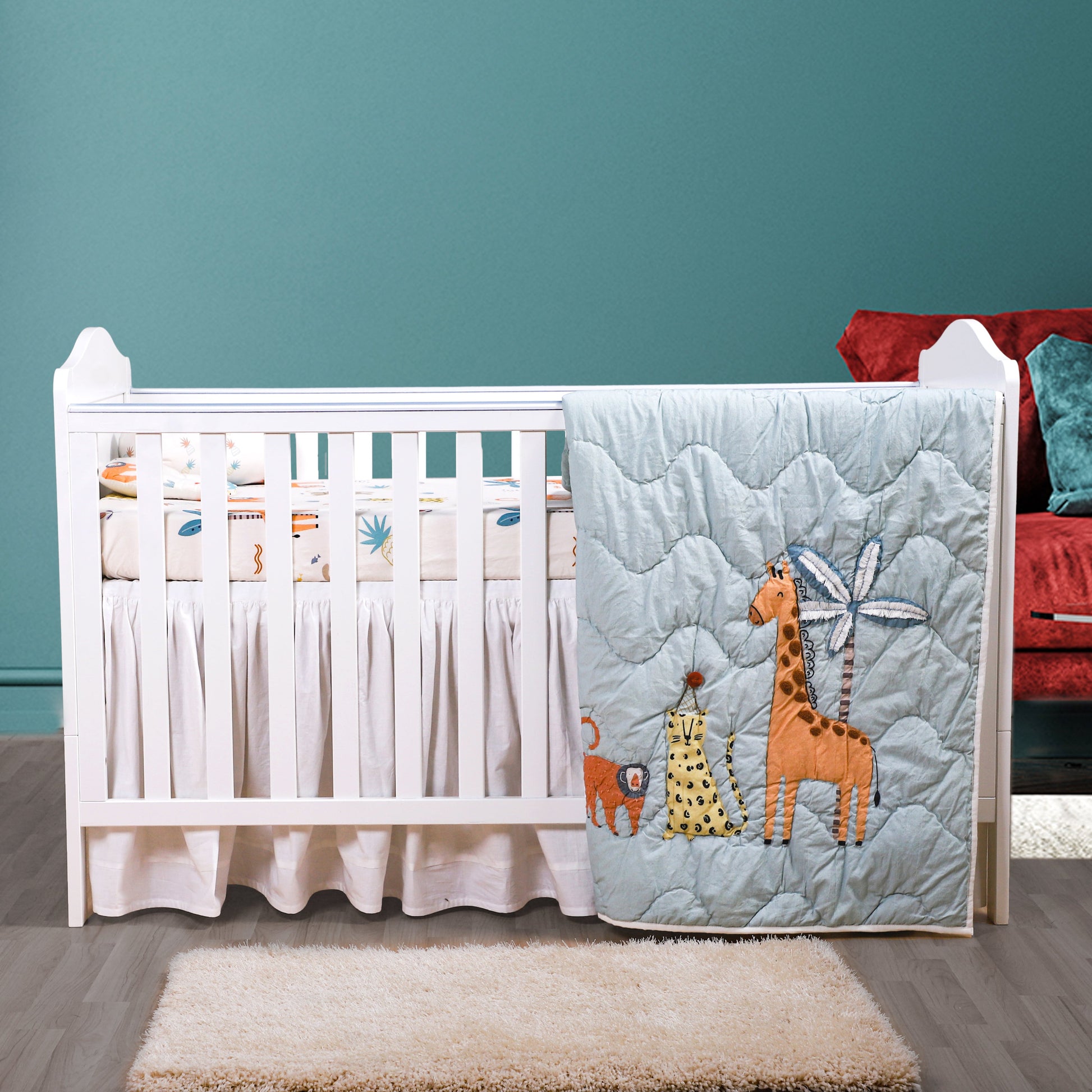 Children's room with a crib, colorful bedding, and toys against a teal wall.