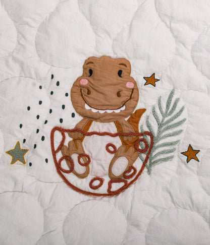 Embroidered design of a monkey in a diaper on a quilt with stars and leaves.