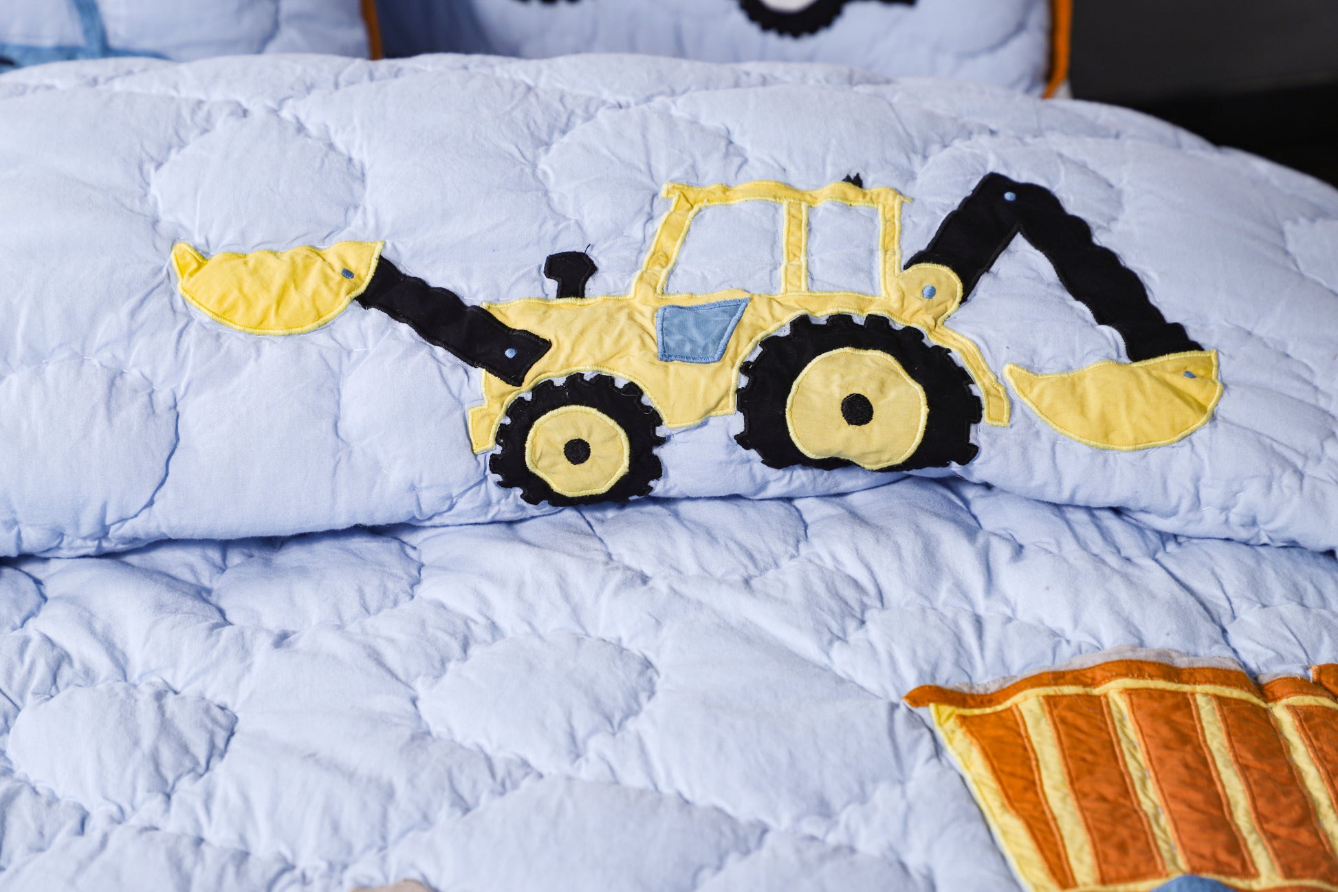 Children's bedding set with a bulldozer design on a light blue background