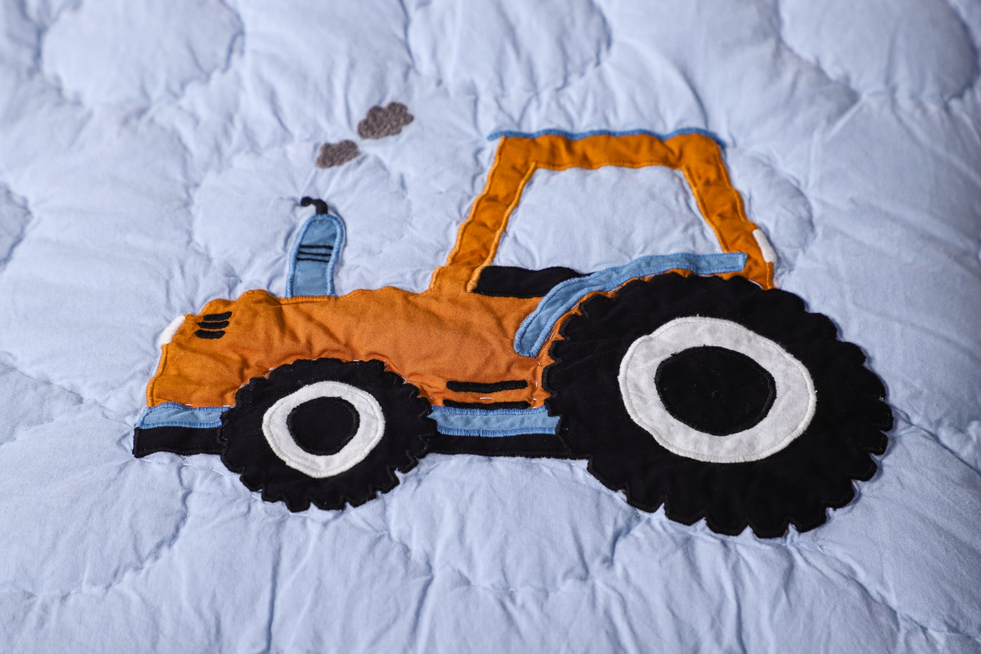 Children's toy tractor on a white quilt
