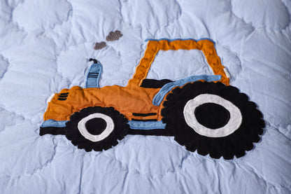 Children's toy tractor on a white quilt