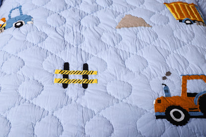 Children's quilt with construction vehicle pattern on a blue background