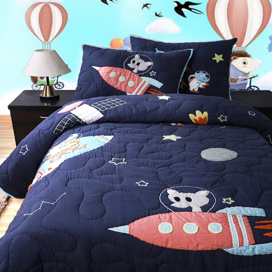 Children's space-themed bedding set with cartoon designs on a bed in a room with hot air balloons and a lamp.