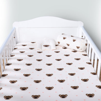 Crib with white sheet featuring brown bear patterns and matching pillow