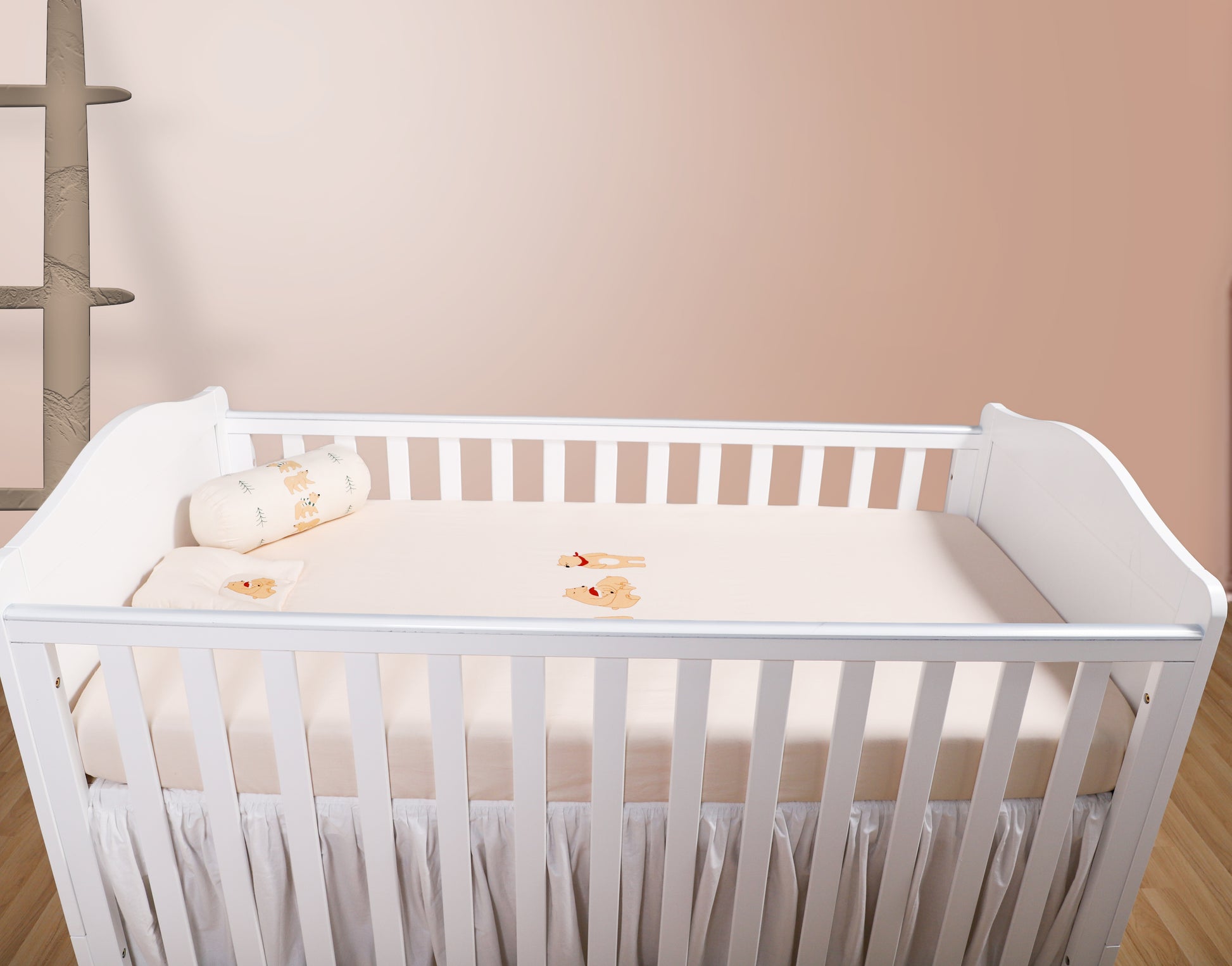 White crib with a beige mattress in a minimalistic room.