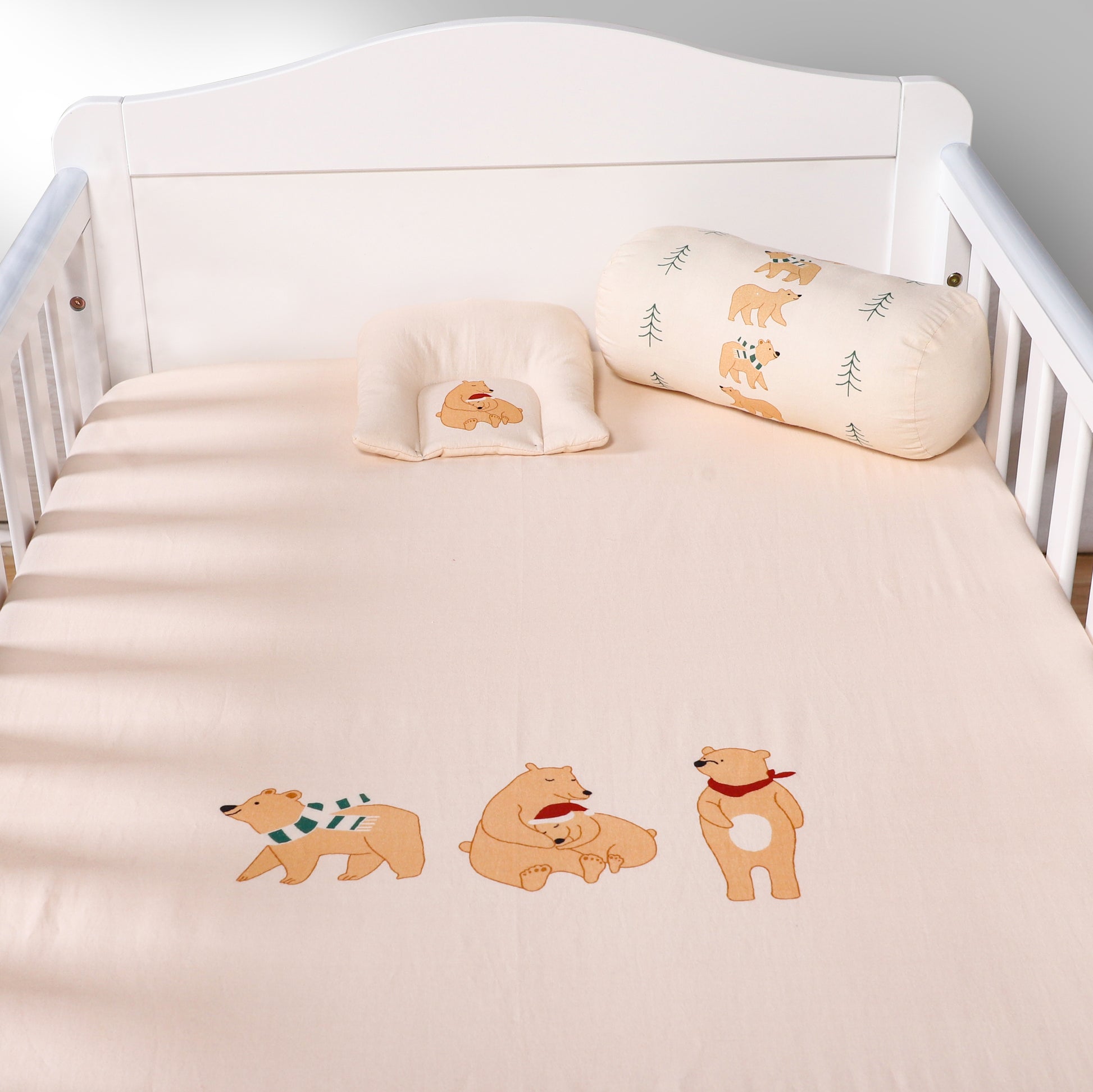 Crib with teddy bear-themed bedding and pillows