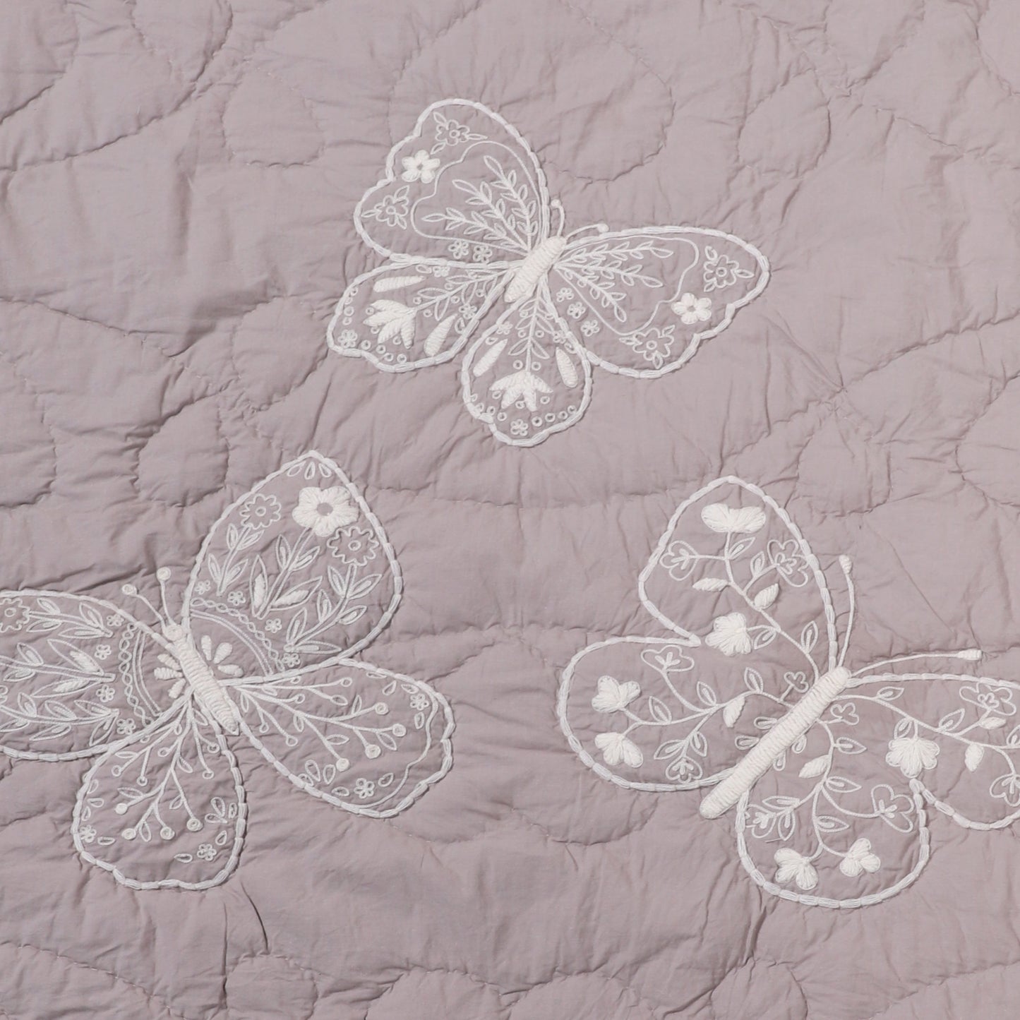Embroidered butterflies on a quilted fabric background