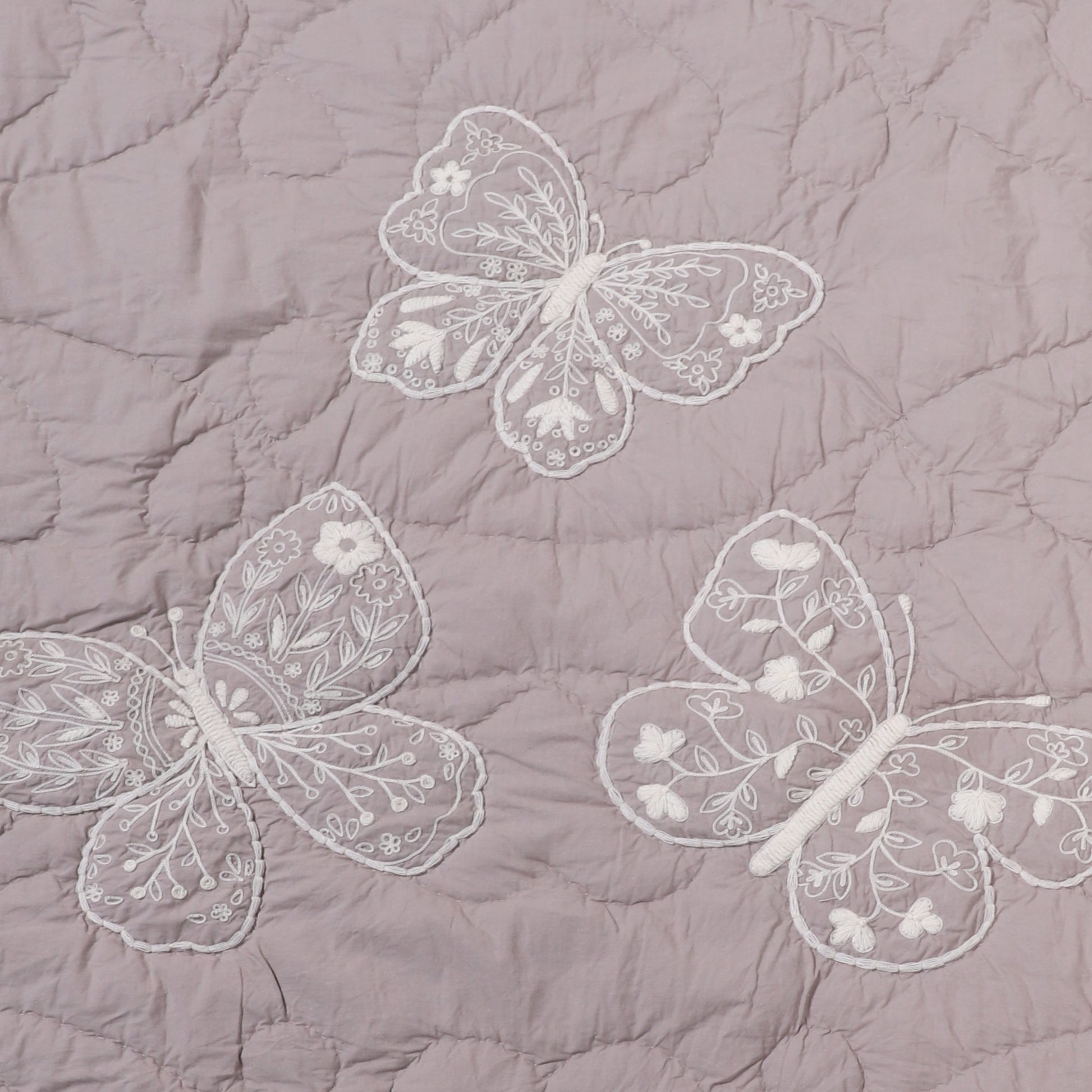 Embroidered butterflies on a quilted fabric background