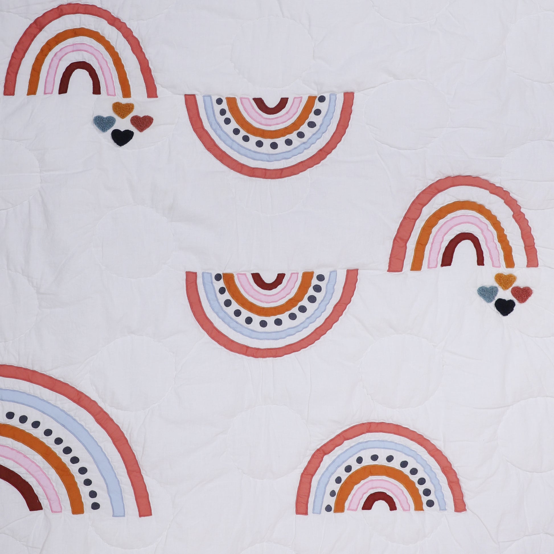 White fabric with colorful rainbow patterns and heart shapes.