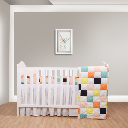 White crib with a colorful quilt in a room with a framed picture on the wall.