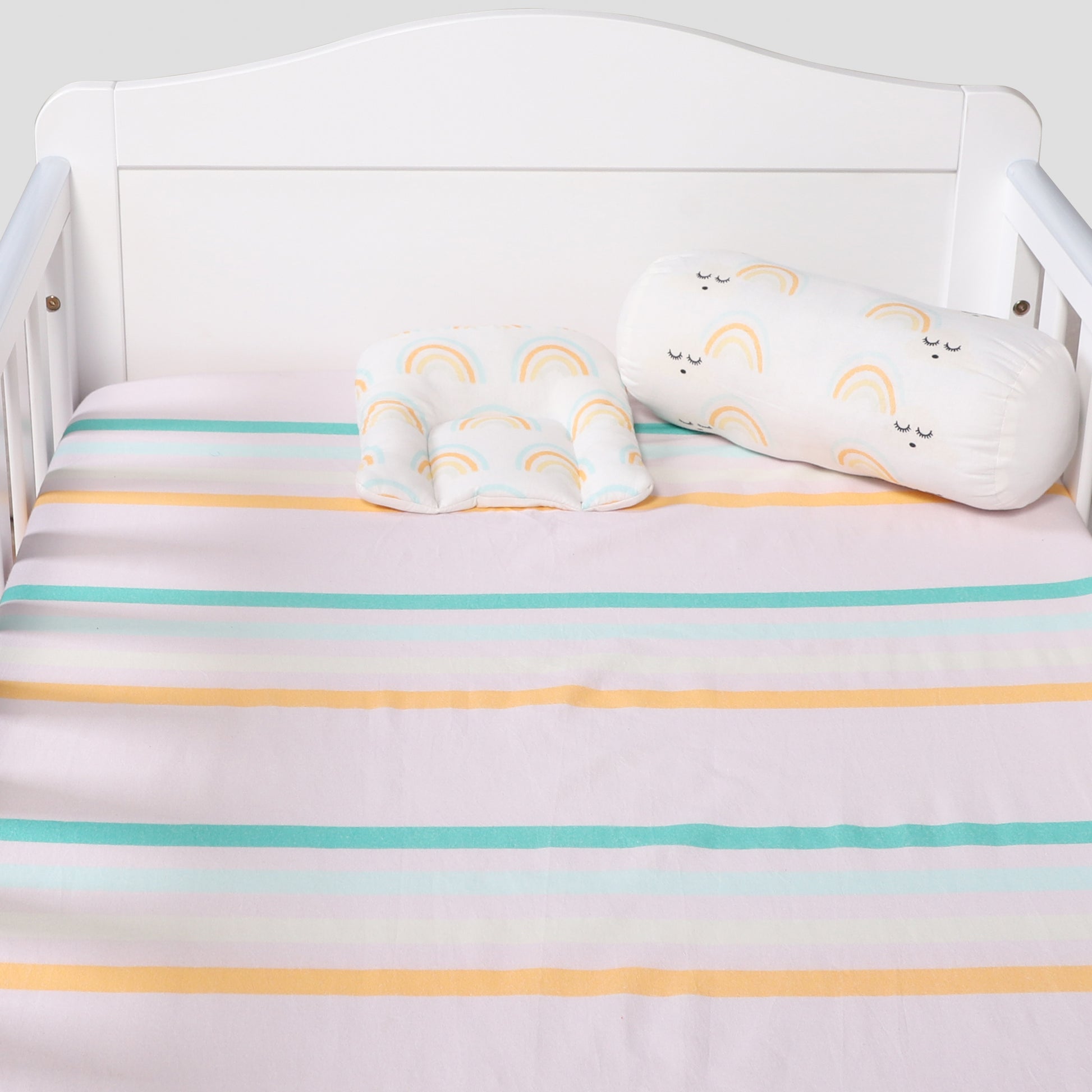 Crib with striped crib sheet and cloud-shaped pillow