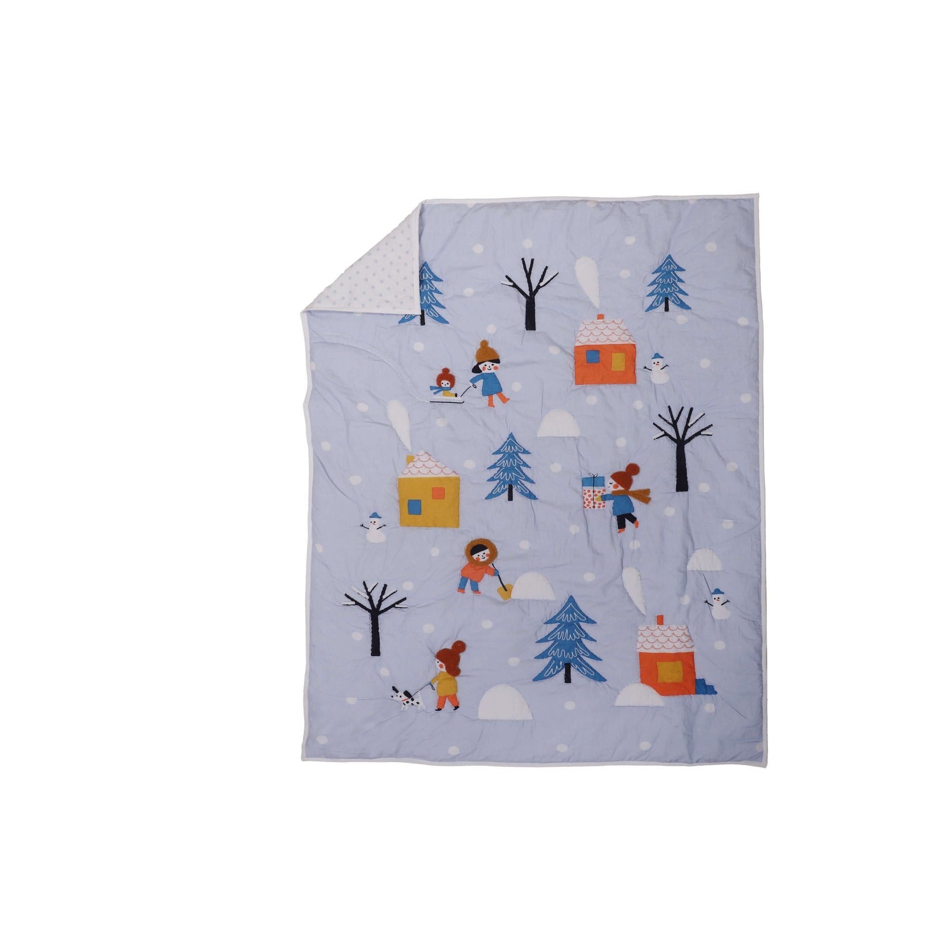 A baby quilt with a winter theme, featuring characters such as a snowman, trees, and possibly a bear, is displayed on a crib.