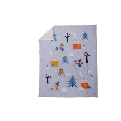 A baby quilt with a winter theme, featuring characters such as a snowman, trees, and possibly a bear, is displayed on a crib.