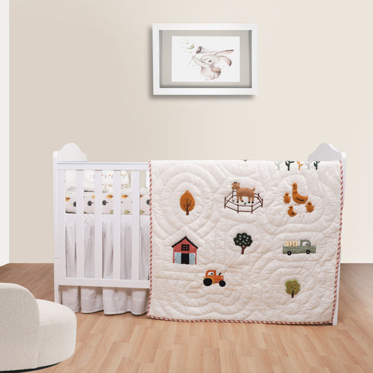 Crib with a quilt featuring farm-themed illustrations in a nursery setting.