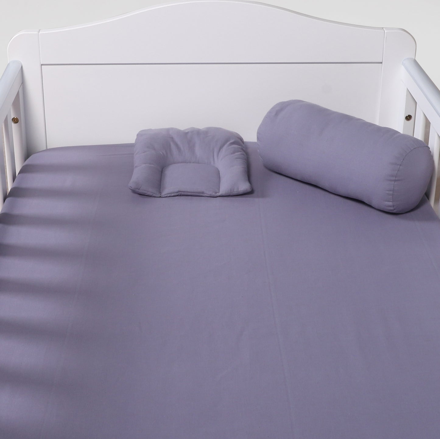 Purple bedding set on a white bed frame