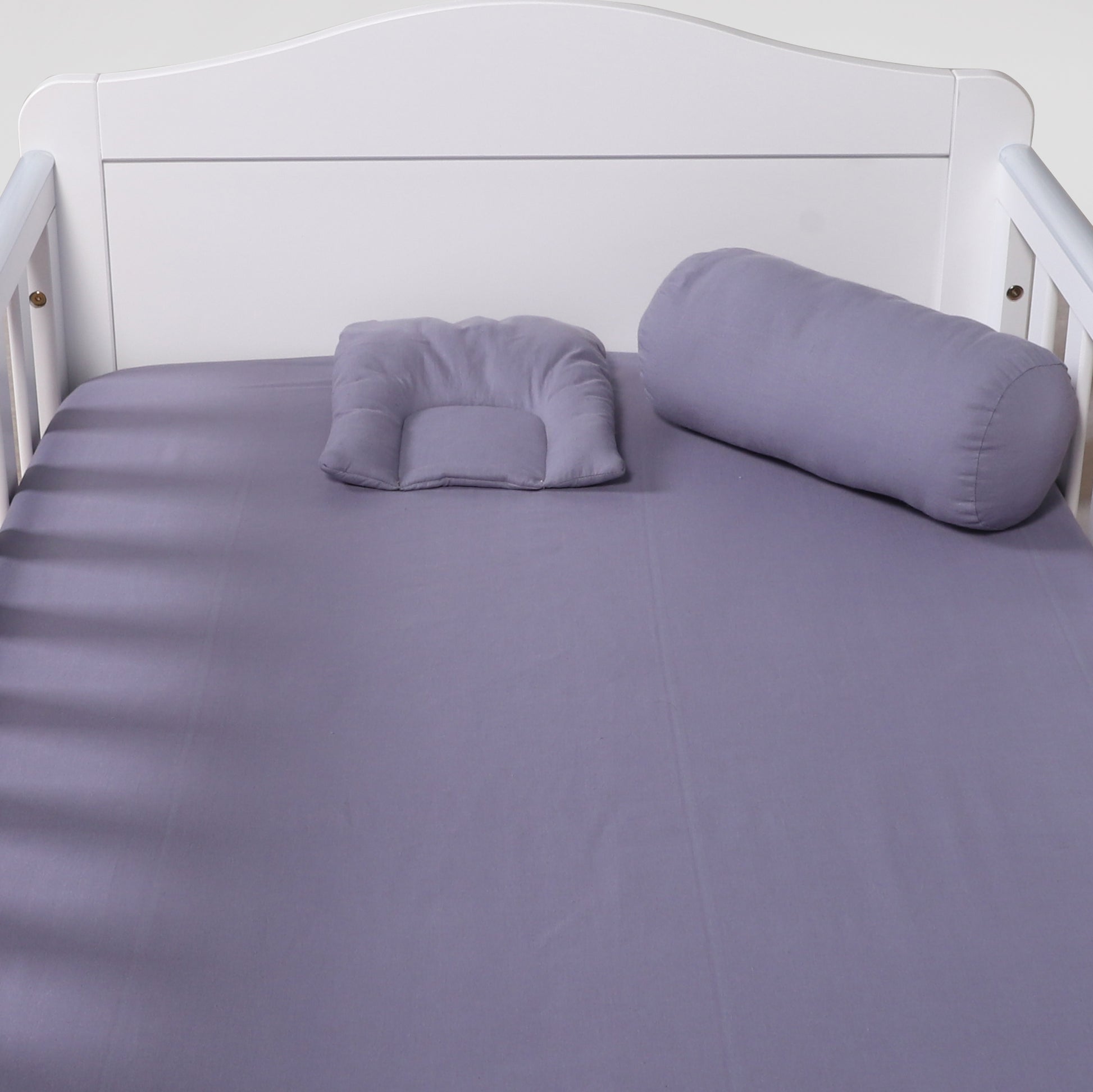 Purple bedding set on a white bed frame