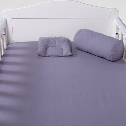 Purple bedding set on a white bed frame