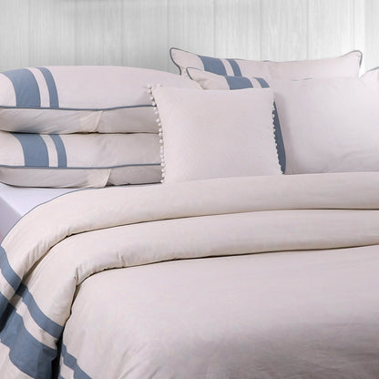 A duvet cover with a striped pattern in beige and blue colors, displayed on a bed with matching pillows.