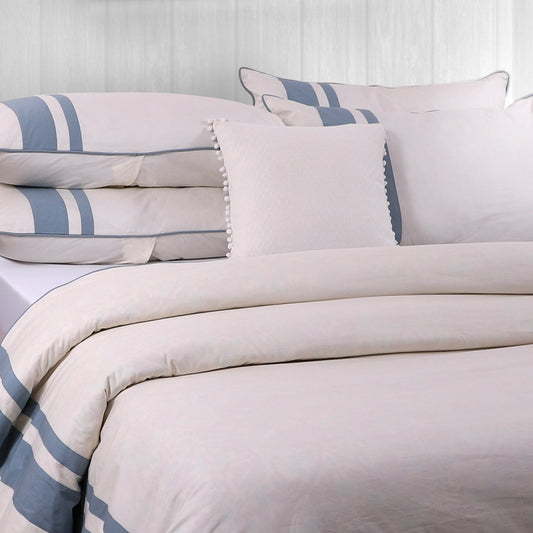 A duvet cover with a striped pattern in beige and blue colors, displayed on a bed with matching pillows.