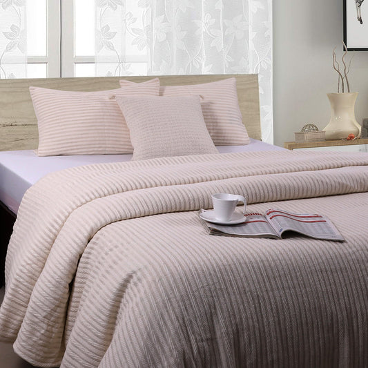 A beige duvet cover with a striped pattern, displayed on a bed in a bedroom setting. The cover appears to be neatly made, with pillows and a cup of coffee placed on the bed.