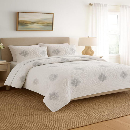 Neatly made bed with floral-patterned bedding in a bright bedroom.