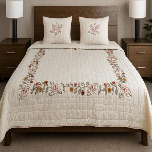 Bed with floral embroidered quilt and matching pillows in a bedroom setting.