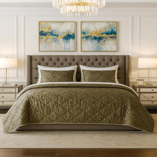Bedroom with a brown quilted comforter on a bed, two abstract paintings on the wall, and two lamps.