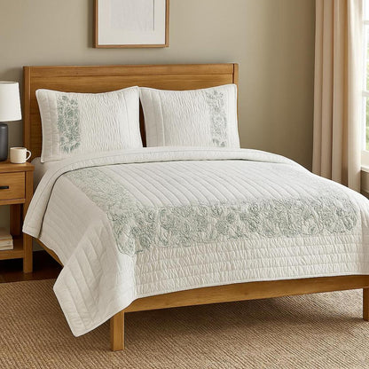 Bedroom with wooden bed, white bedding with green embroidery, and nightstand.