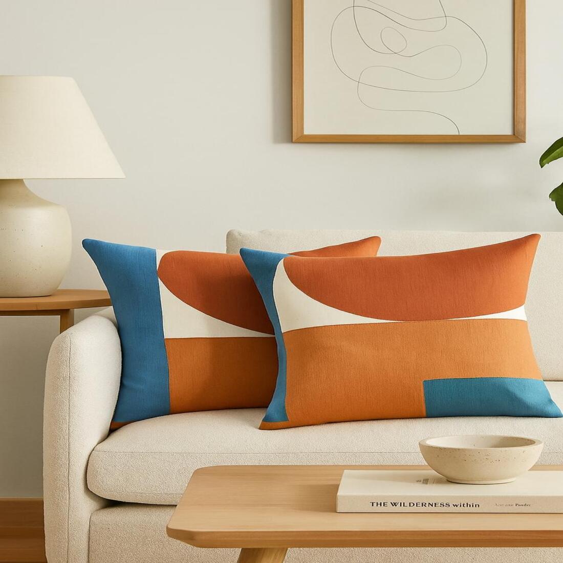 Decorative pillows on a beige sofa with a wooden coffee table and abstract art in the background.