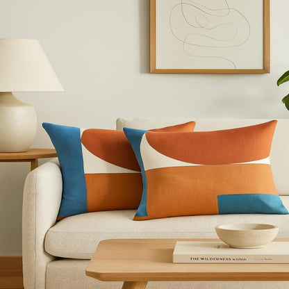 Decorative pillows on a beige sofa with a wooden coffee table and abstract art in the background.