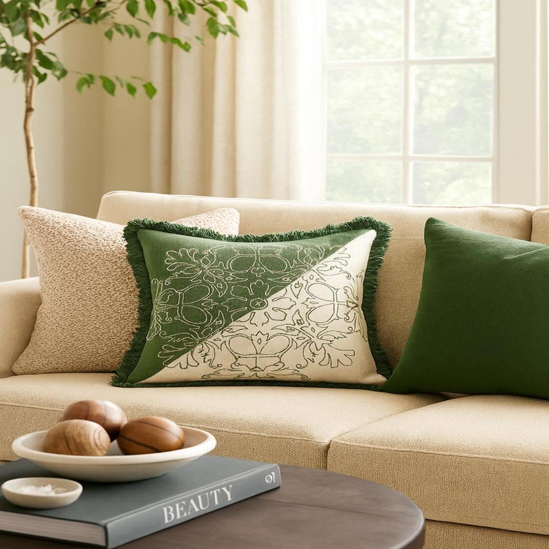 Beige sofa with decorative pillows and a small table in a living room setting.