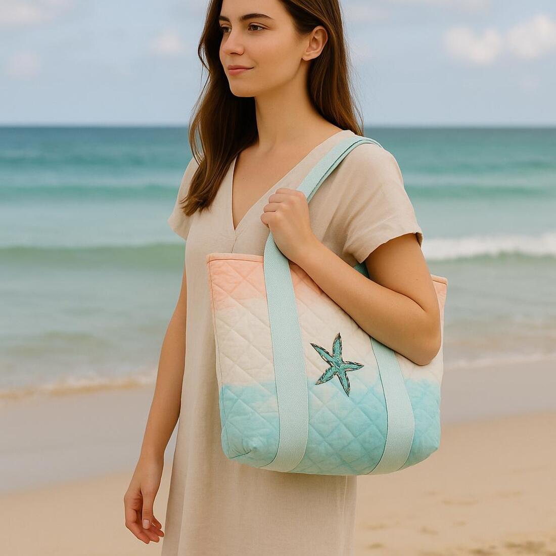 Woman holding a beach bag with a starfish design on a beach