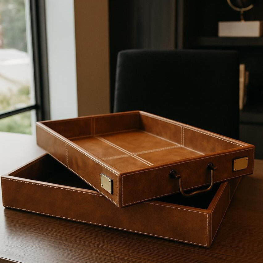 Brown leather tray with gold accents on a wooden surface