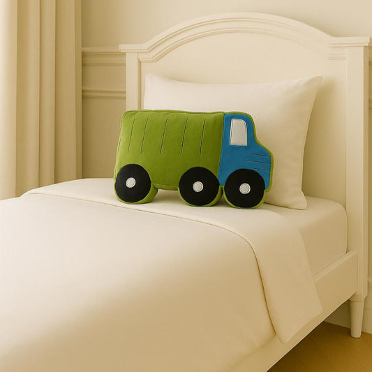Children's toy truck on a bed with white bedding and a white headboard.