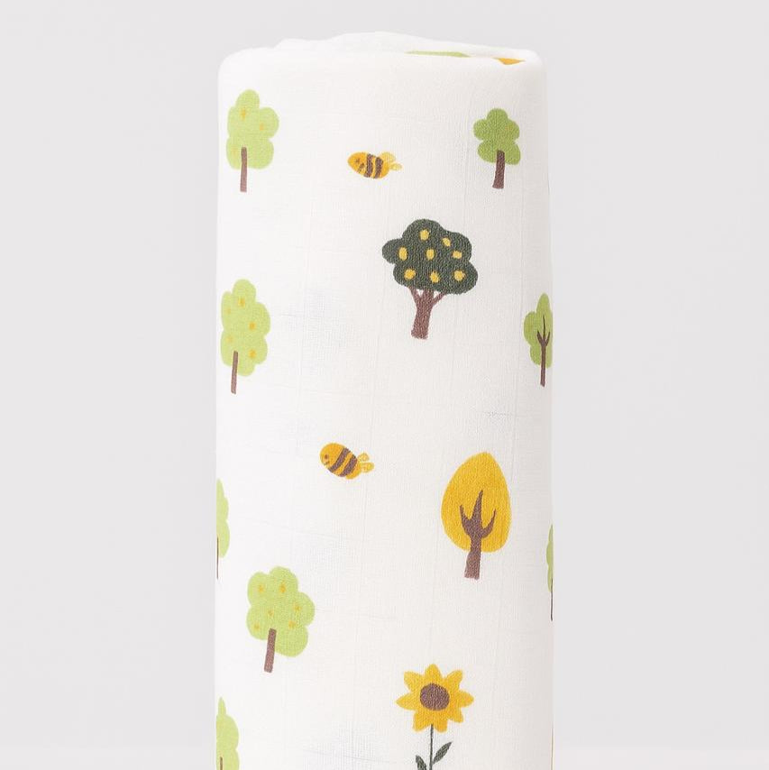Roll of fabric with tree and bee pattern on a white background