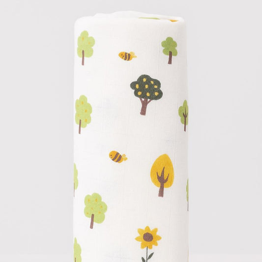 Roll of fabric with tree and bee pattern on a white background