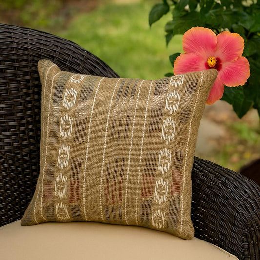 Decorative pillow with a pattern on a wicker chair with a pink flower in the background