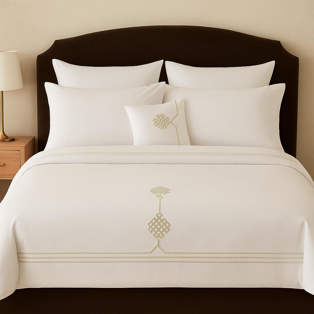 Neatly made bed with white bedding and decorative pillows in a bedroom setting.