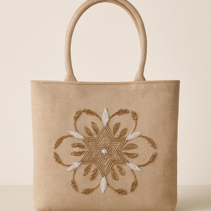 Beige tote bag with intricate gold embroidery on a beige background