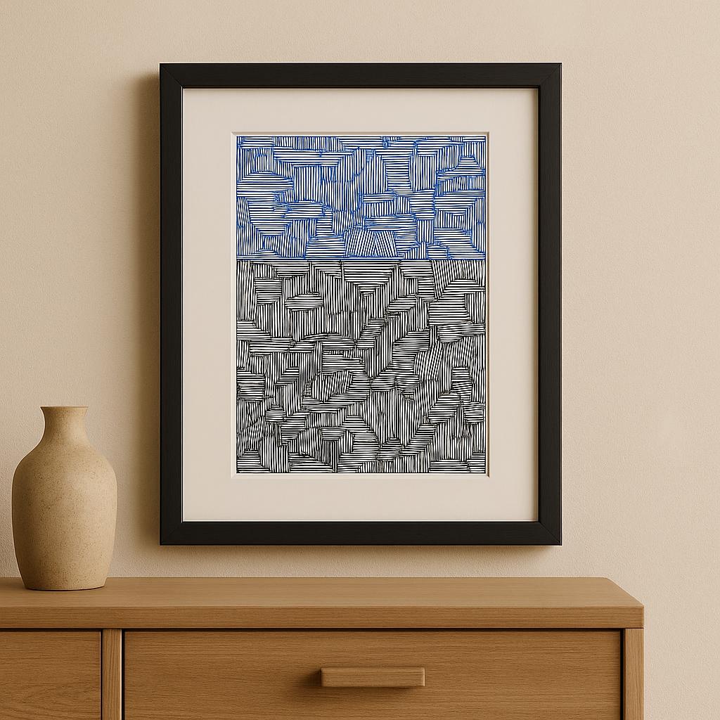 Framed abstract artwork with blue and gray patterns on a beige wall above a wooden cabinet.